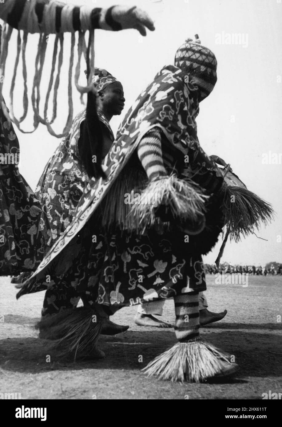 Sein Kopf war vollständig bedeckt und in einem farbenfrohen, mit Stroh getrimmten Kleid gekleidet. Dieser ian-Stammesmann gehörte zu den 7.000, die am Donnerstag (2-2-56) vor der Königin bei der Kaduna-Kundgebung vormarschierten. 17. Februar 1955. (Foto von Daily Mirror).;sein Kopf war vollständig bedeckt und in einem farbenfrohen, mit Stroh getrimmten Kleid gekleidet.dieser ian-Stammesmann gehörte zu den 7.000, die am Donnerstag (2-2-56) bei der Kaduna-Kundgebung vor der Königin vormarschierten. Stockfoto