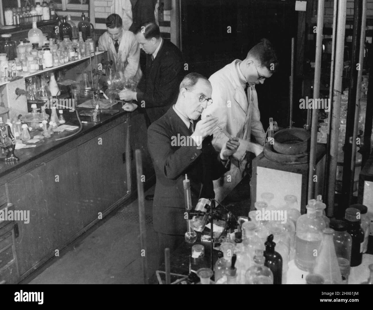 Penicillin, Vergangenheit, Gegenwart und Zukunft -- am Imperial College of Science, London, Professor I.M. Heilbron (Vordergrund) und Doktor A.H. Cook arbeiten ebenfalls an dem Problem der Synthese. Professor Elibron war früher Professor für Organische Chemie an der Universität Manchester und gewann einen internationalen Ruf für seine Arbeit über Vitamin A. "Wir kennen die einfachen Fragmente", sagt D. Cook, "wie viele Fenster, wie viele Türen Penicillin hat. Jetzt arbeiten ohne die sind ***** Planen. Die von uns produzierten Stoffe sind Stockfoto