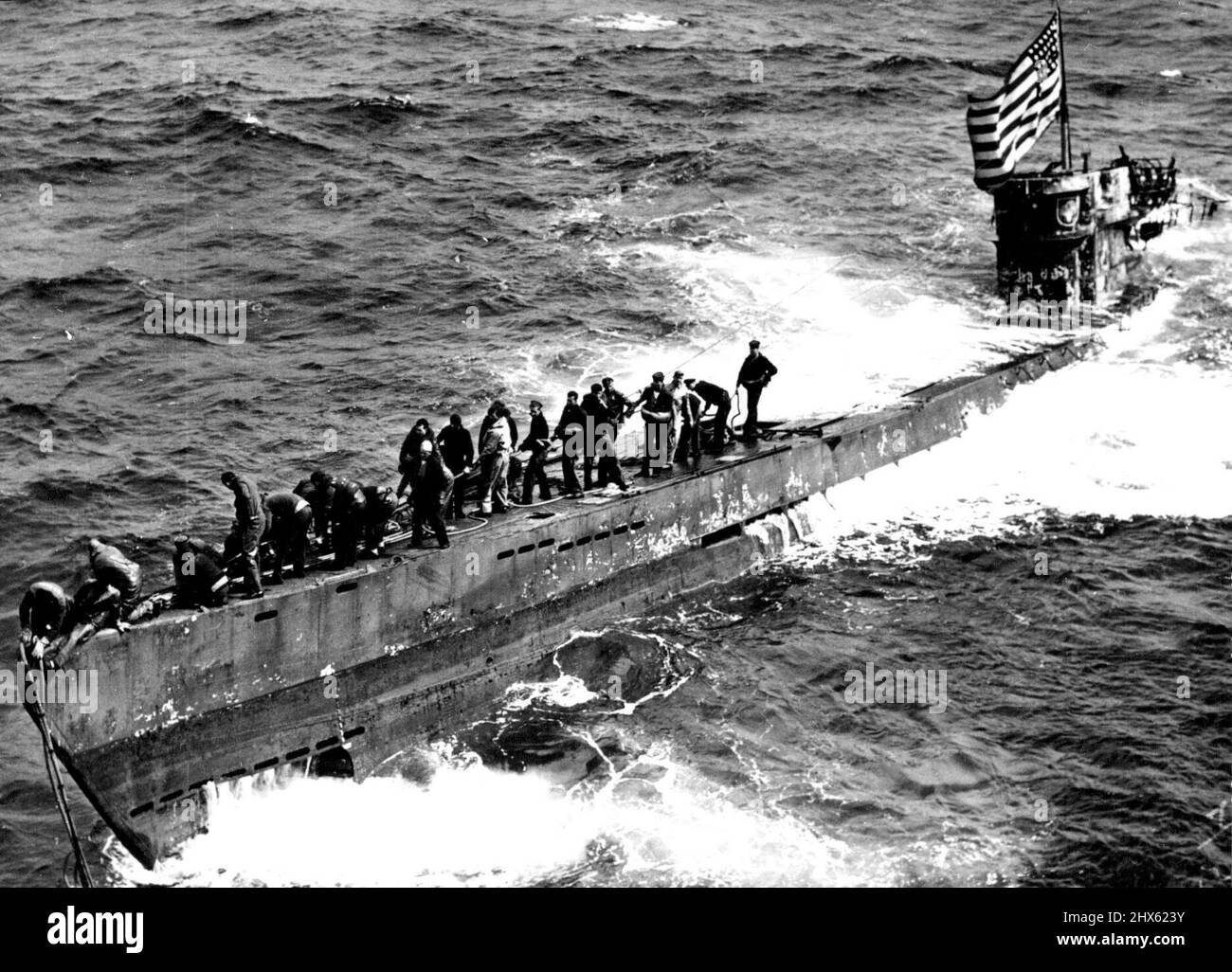 Die deutsche U-Boot-Flotte wurde von -- US Navy Ships vor Westafrika -- Eine Schleppleine wird auf dem Bug der gefangenen U-Boot-Marine durch ein Mitglied der Marine Boarding Party gesichert Guadalcanal, der die U-505 vier Tage lang schleppte, bis ein Navy-Schlepper ankam, um die 2.500 Meilen (4.000 km) zu übernehmen, die zum Marinestützpunkt auf Bermuda gebracht wurden. Das feindliche Schiff überschwemmt noch immer mittschiffs, aber das Navy-Personal hat es geschafft, weitere Überschwemmungen zu verhindern und das hochgezogen Stockfoto