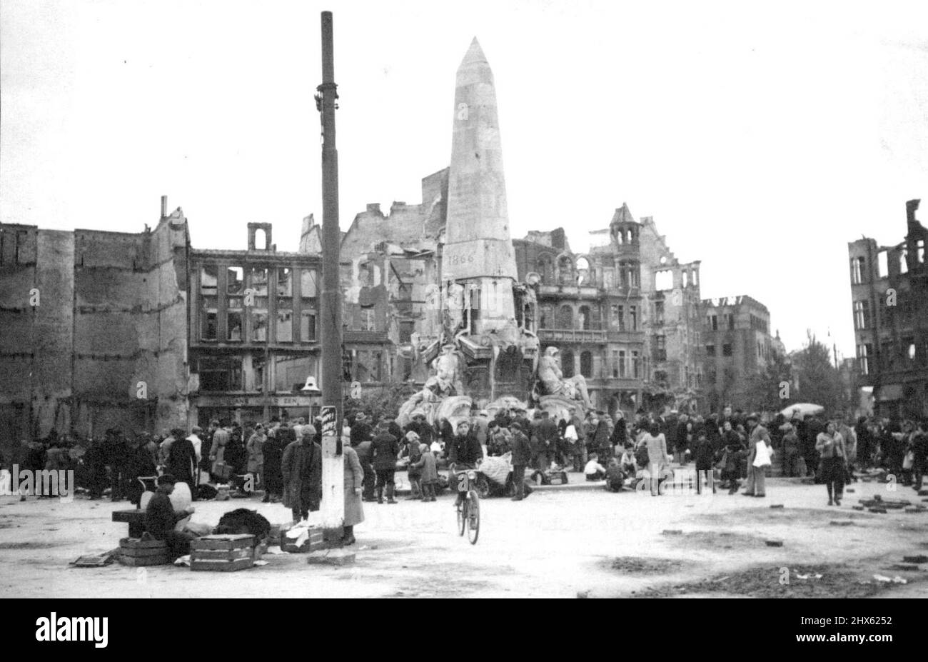 Deutsche verkaufen sich an Polen in Danzig -- die überfüllte Szene auf einem Marktplatz in Danzig, da die Deutschen die Stöcke über die Pfähle werfen. Die Deutschen verfügen über Rasseln an den Polen. Gebäude, die durch deutsche Angriffe und alliierte Bombenangriffe zerstört wurden, sind im Hintergrund zu sehen. Deutsche, ehemalige Bewohner von Danzig, befahlen nun, zu evakuieren. An die Reichen, verkaufen die meisten ihrer Habseligkeiten an die Pole - jetzt Meister des baltischen Hafens - vor der Abreise in das Vaterland. 18. Oktober 1945. (Foto von Associated Pres Stockfoto