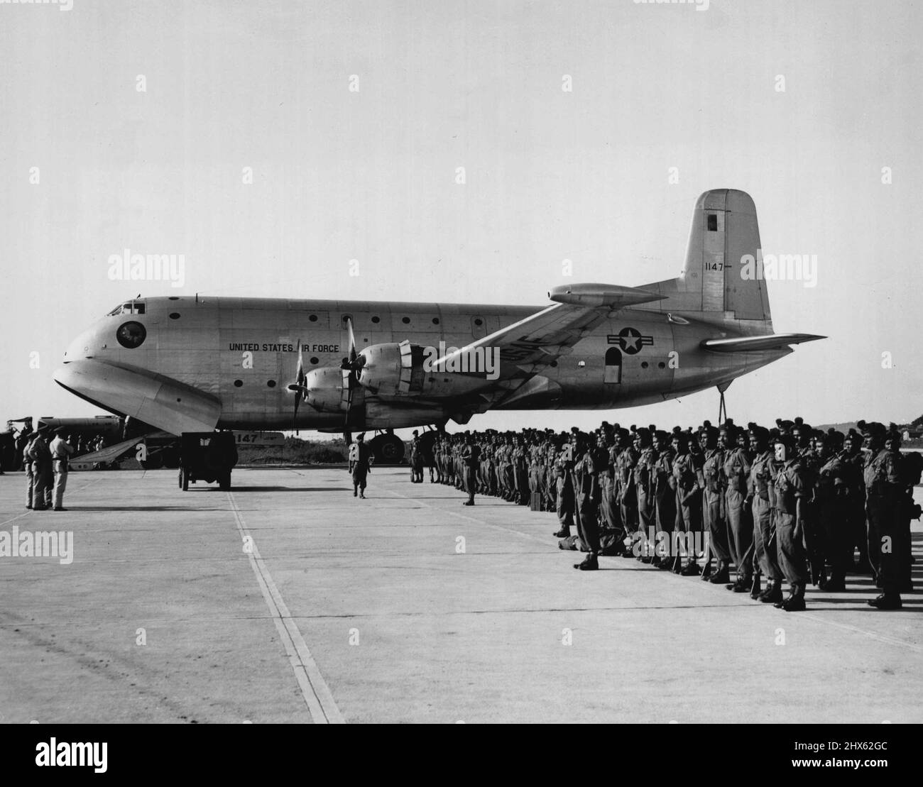 C-124 Globemaster nimmt an der Operation Handclasp Teil Ein C-124 Globemaster der 315. Air Division steht auf einer Fluglinie in Japan zur Verfügung, während Soldaten der Vereinten Nationen vor dem Flug eine Einweisung erhalten. Zwei der riesigen C-124s werden an der Operation Handclasp II' teilnehmen, einem Geschäfts- und Ausbildungsflug von Japan nach Australien. Die C-124s wird für die Luftauftriebswartung und das Hilfspersonal verwendet und auf mehreren australischen Luftwaffenstützpunkten auf einer statischen Anzeige aufgestellt. 23. Februar 1955. (Foto Stockfoto