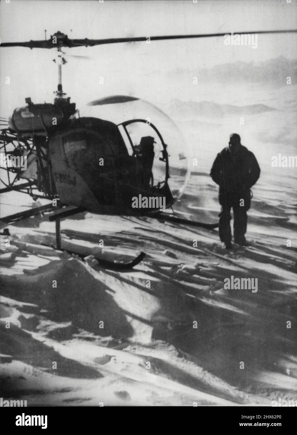 Helikopter am Mount Blanc der französische Pilot Jean Moine wird hier neben seinem amerikanischen Bell 47-G-Hubschrauber auf dem Mount Blanc, 15, 781 Fuß, Europas höchstem Berg, gestern, am 6. Juni gezeigt. Er behauptet, dies sei ein neuer Rekord für die höchste Hubschrauberlandung - der vorherige Rekord wurde von einem Franzosen gehalten, der auf der jungfrau, 13, 653 Fuß, in der Schweiz landete. Moine, der Bergführer Andre Contanine als Beifahrer mitnahm, verbrachte etwa vier Minuten auf dem Gipfel. 23. Juni 1955. (Foto von Associated Press Phot Stockfoto