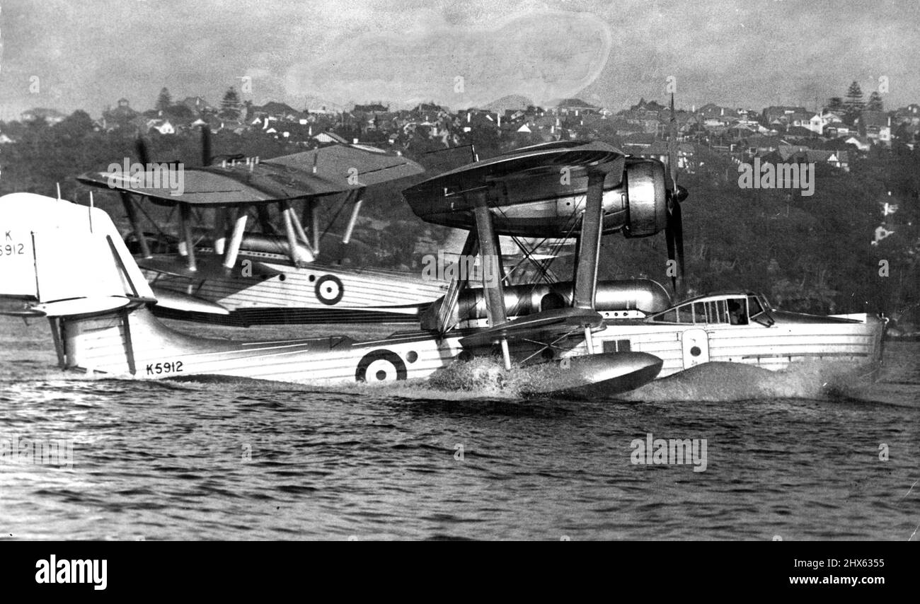 Flying-Boats Heben Ab. Ein ungewöhnlicher Effekt wurde erzeugt, als zwei der britischen Flugboote, die heute nach Melbourne und nach Hause fuhren, sich im Hafen passierten. Der im Hintergrund hat das Wasser verlassen. Der andere wirft Spray auf, um die anderen beim Start zu drehen und ihnen zu folgen. 4. März 1938. Stockfoto