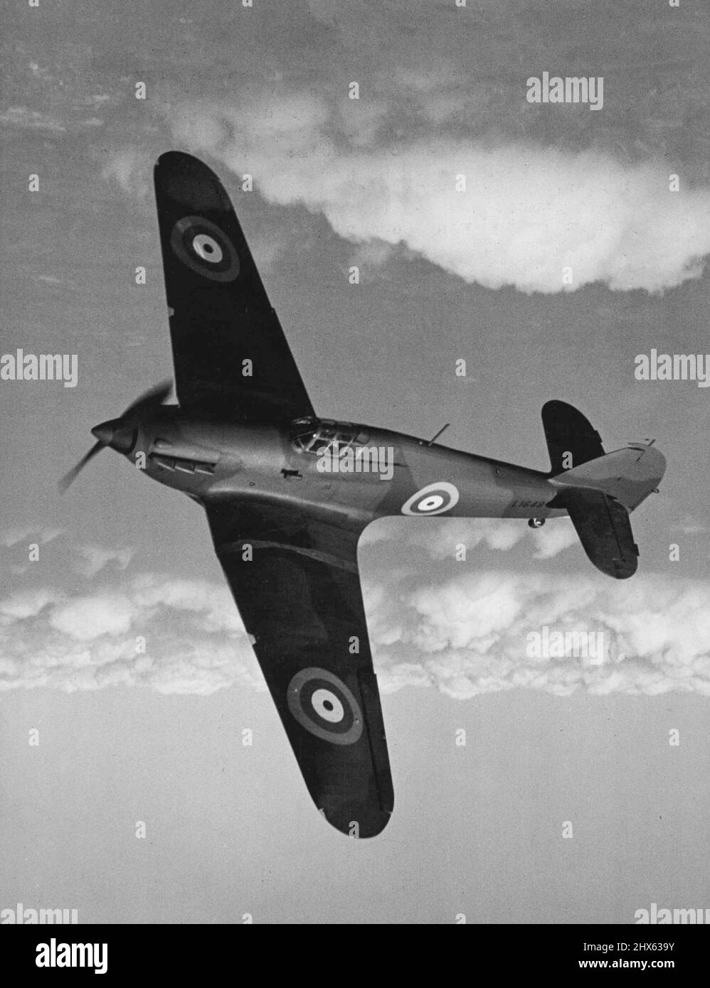 Weit über die Vertikale der Pilot eines Hawker-Sturmjägers führt ein erstaunliches Seitenrutschmanöver durch, das das Power-Plus-Streamline-Design dieses gewaltigen Kampfflugzeugs enthüllt, das jetzt die Verteidigungsgeschwader der Royal Air Force neu ausrüstet. Angetrieben von einem Rolls-Royce Merlin-Motor, der 1.050 PS leistet, hat der „The Huancee“ eine beeindruckende Leistung und ist in der Lage, Hochgeschwindigkeitskämpfe und Abhörarbeiten zu bewältigen. Acht Waffen, die in den Flügeln untergebracht und ausgerichtet sind, um einen Sturm des Vorwärtsfeuers zu geben, haben sich verdient Stockfoto