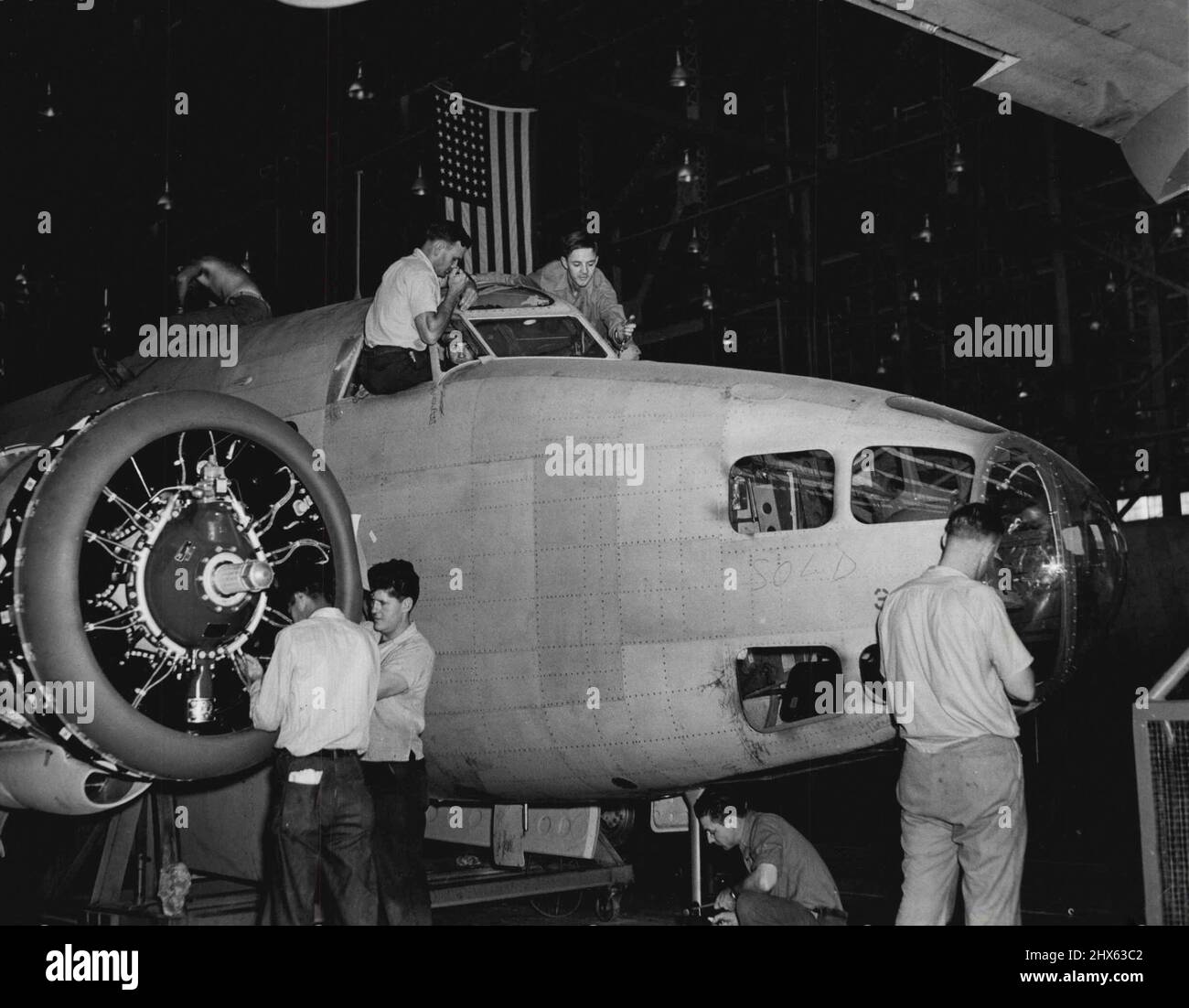 Einen Bomber bauen -- auf einem anderen Bild sah man Palmer an einem Flugzeugmotor arbeiten. Gründlich vertraut mit Flugzeugbau, Er ist oben gezeigt (links) arbeiten an der Windschutzscheibe eines Lockheed Hudson Bomber. Beachten Sie, dass etwas Wag auf dem Rumpf in der Nähe der Nase „verschnürt“ hat. 18. Juli 1941. (Foto von ACME). Stockfoto