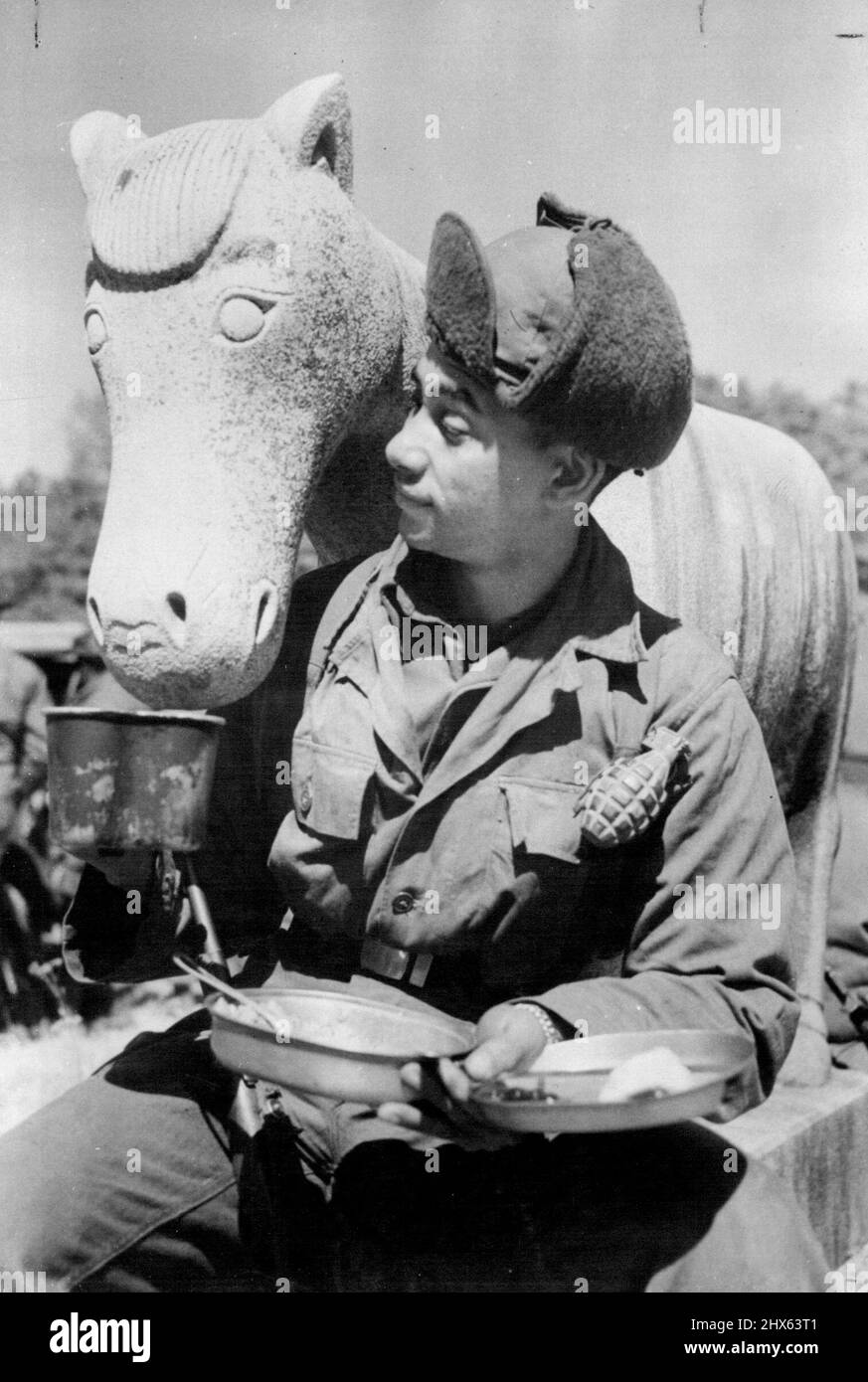 Steinige Weigerung in Korea: Sanfter Humor aus der düsteren Kriegslandschaft Koreas trägt dieses Bild des amerikanischen Infanteristen Private (Pirutklasse) William E. Kellogg, der einem steinernen Pferd seinen Kaffee im Kamgong-Ni Tempel, 12 Meilen östlich von Seoul, anbietet. Das Pferd hielt ein ***** Ein Stil, der von vielen modernen Bildhauern bevorzugt wird - le eloquent genug für Kunststudenten. 6. April 1951. (Foto von Reuterphoto). Stockfoto