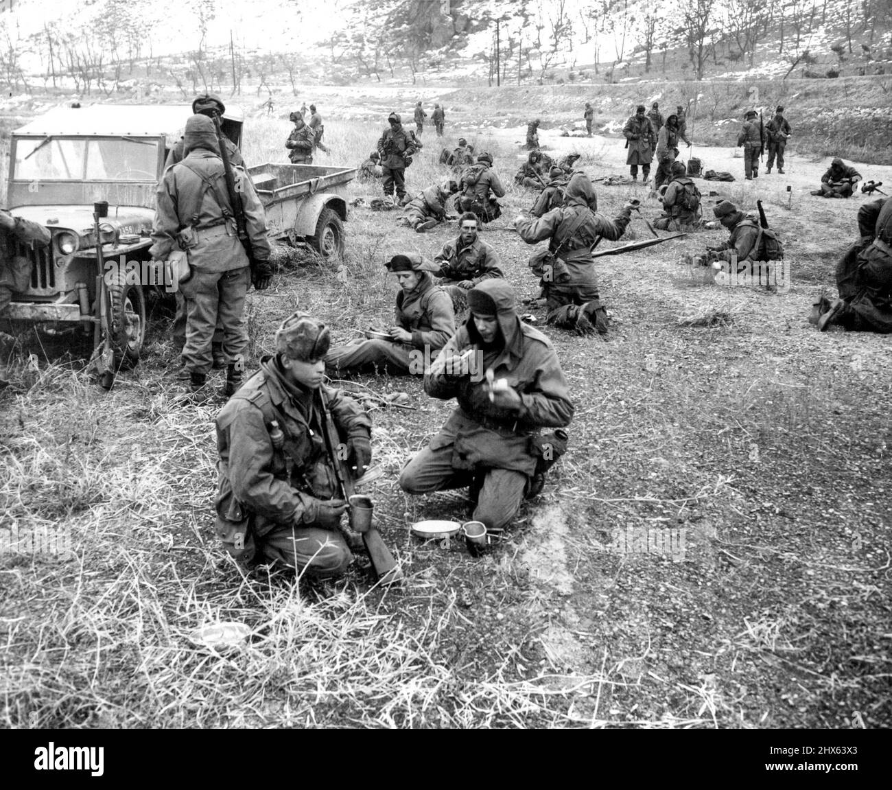 Ein Tag mit den 25. (erster von zehn) - 'Breakfast NOOK' für GI's der 25. Division an einem kalten Februarmorgen ist ein offenes Feld. Das Essen wurde in einem Anhänger am Jeep (links) gebracht. 3. Februar 1951. (Foto von ACME). Stockfoto