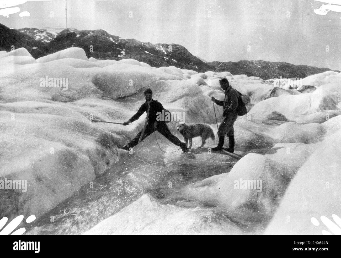 British Arctic Air Route Expedition - Scott und Lindsay überqueren einen Taustrom in der Mitte des Gletschers. 15. September 1931. (Foto der British Arctic Air Route Expedition). Stockfoto