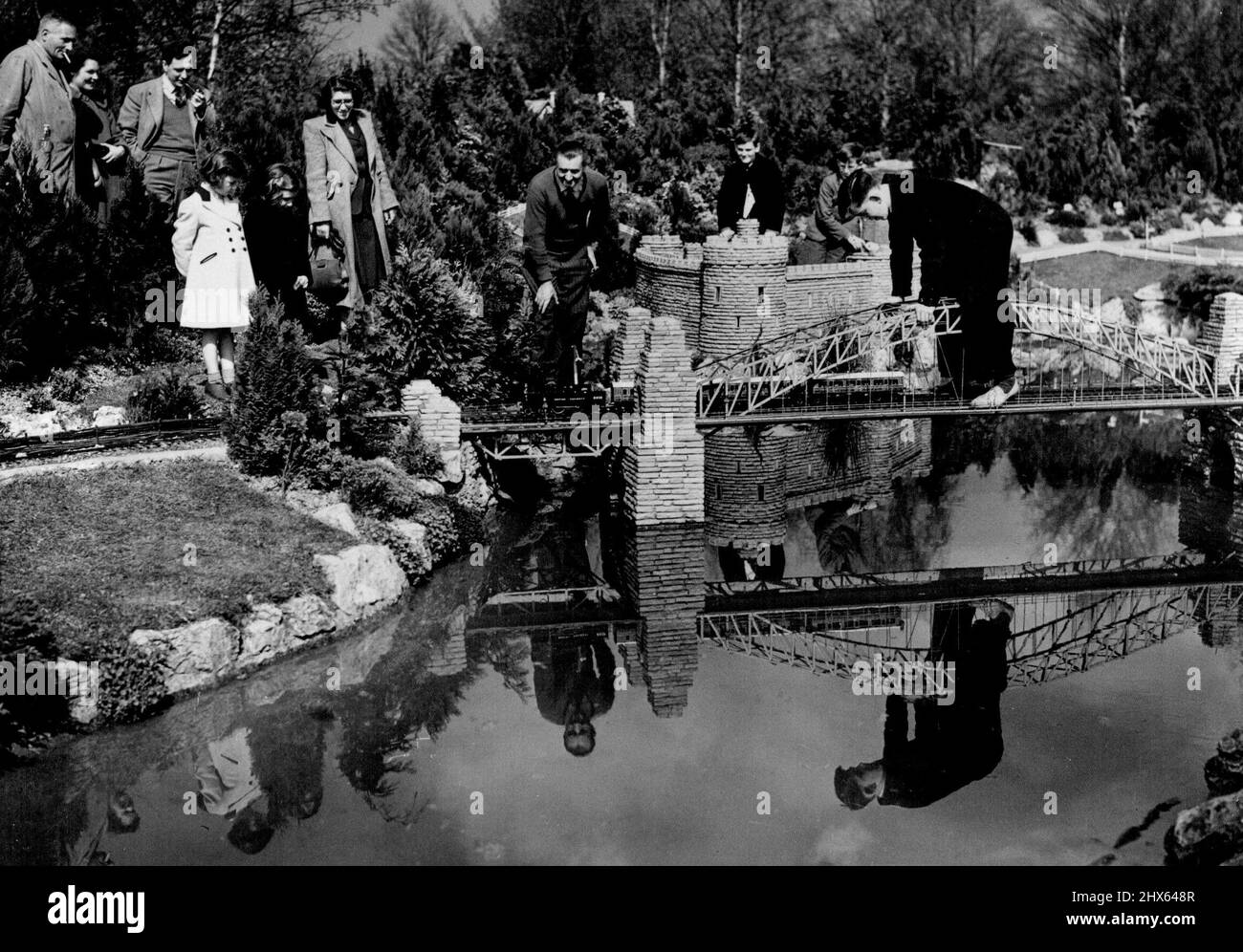 Eine Million Besucher sehen Tiny Town, doch der Model Village Way muss schließen -- Besucher beobachten, wie ein Zug über das Modell der Sydney Harbour Bridge fährt, während Spiegelungen der Brücke im Wasser darunter zu sehen sind. Die berühmte Modelleisenbahn und Miniaturgärten, die als gemeinnütziger Verein geführt wurden, werden bald den millionsten Besucher in Beaconsfield, Bucks, Heimat markiert haben. Trotz dieser Tatsache könnte der Bezirksrat von Bucks die Gärten in naher Zukunft schließen. Ein Modell von Sydney Harbour Bridge Stockfoto