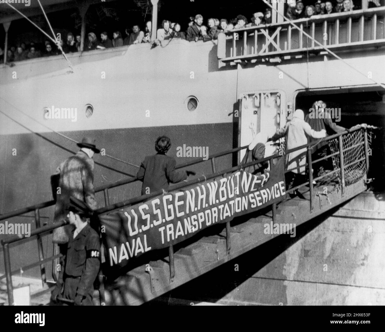 Amerikaner verlassen Tsingtao -- mehrere Personen gehen am 1. Dezember die Bandenplanke des General Butner, US-Marinetransportes, hinauf, um Tsingtao zu verlassen. Amerikanischer Marinestützpunkt in der Nähe der Szene der nationalistisch-kommunistischen Kämpfe Chinas. Dutzende anderer Amerikaner säumen das Geländer des Schiffes, um den Exodus zu beobachten. Alle sind für die Vereinigten Staaten gebunden. 3. Dezember 1948. (Foto von AP Wirephoto). Stockfoto