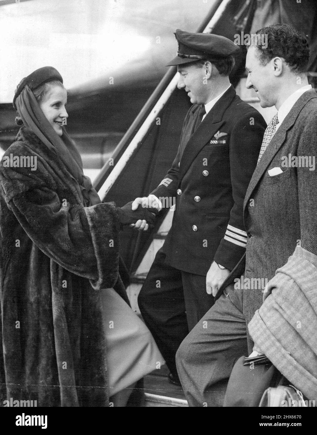 Diana Wynyard führt Shakespeareans auf einer 14-wöchigen Tour durch Australien an -- Diana Wynyard, das Flugzeug, Captain R. Uren, am Flughafen London. Rechts ist Anthony Quayle, der Direktor. Mitglieder der Shakespeperian Memorial Theatre Company aus Stratford-on-avon, angeführt von Diana Wynyard und Anthony Quayle, dem Regisseur, verließen den Flughafen London durch den Flughafen von B. O. A. C. - Qunatas für eine 14-wöchige Tour durch Australien und Neuseeland. Es wird angenommen, dass das Unternehmen das größte Theaterunternehmen ist, das je gereist ist Stockfoto