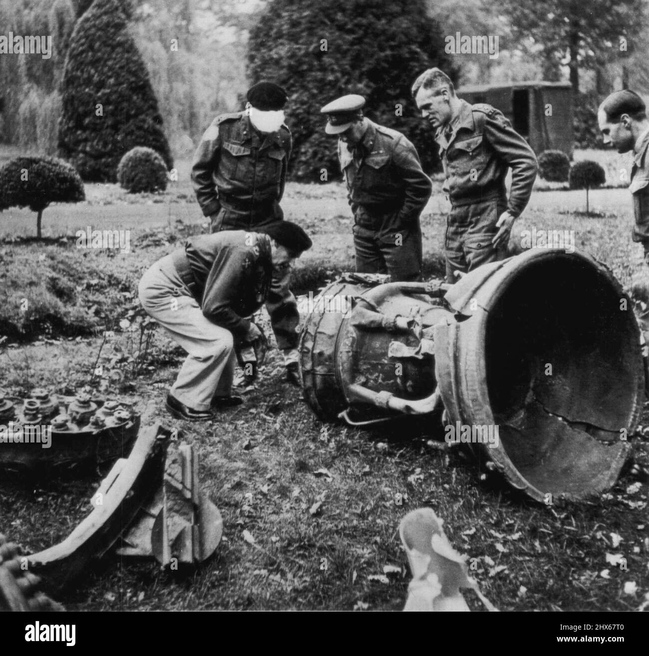 Montgomery untersucht deutsche Rakete - der eingereichte Marschall Sir Bernard L. Montgomry (links) und andere britische Offiziere untersuchen eine deutsche V-2-Rakete, die sich in einem Feld in Belgien anfühlt und explodiert. Der Zensor hat das Gesicht eines Beamten abgezeichnet. 4. Dezember 1944. (Foto von AP Wirephoto). Stockfoto