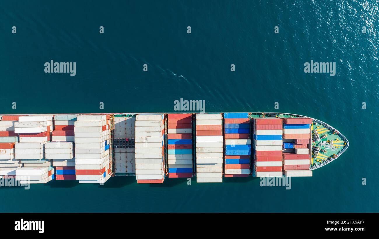Luftaufnahme von oben des Frachtschiffes, das Container transportiert und für Exportgüter vom Hafen der Werft bis hin zum maßgeschneiderten Technologie-Transport des Ozeans läuft Stockfoto
