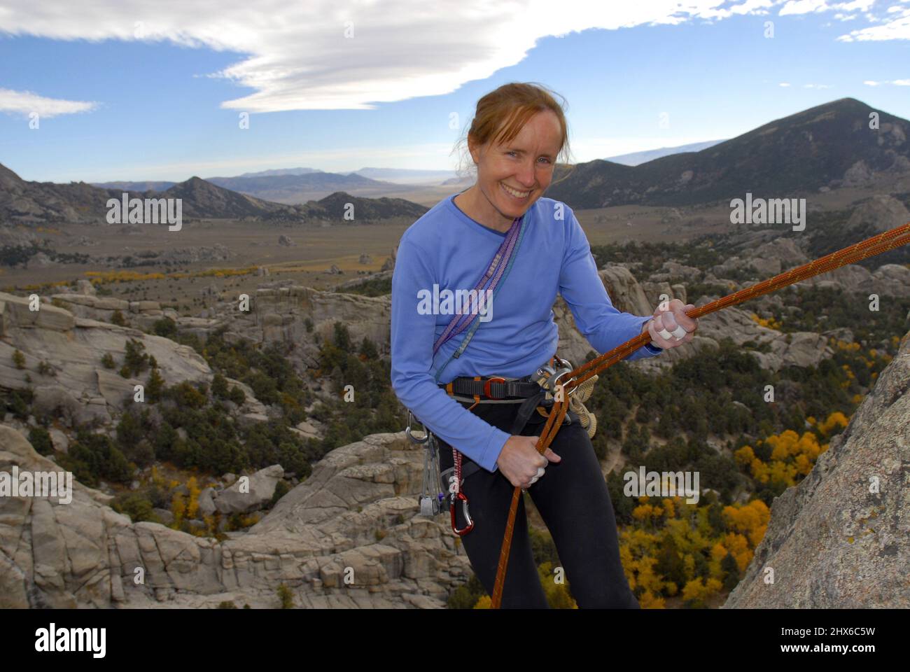 Eine alleinstehende Klettererin erklimmen die senkrechte Klippe in City of Rock, Idaho Stockfoto