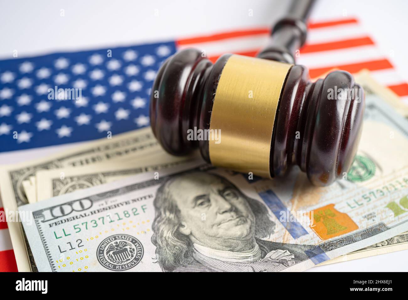 Gavel für Richteranwalt und US-Dollar-Banknoten auf US-amerikanischer Flagge, Finanzierungskonzept. Stockfoto
