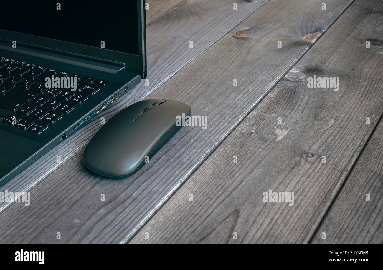 Laptop und Computer Moderne Maus Nahaufnahme auf einer dunklen Holzoberfläche. Stockfoto