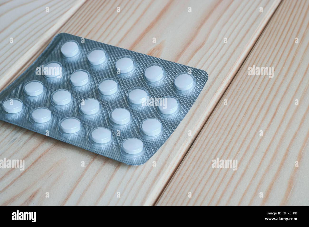 Verpackung von Pillen auf einer hellen Holztischoberfläche. Stockfoto