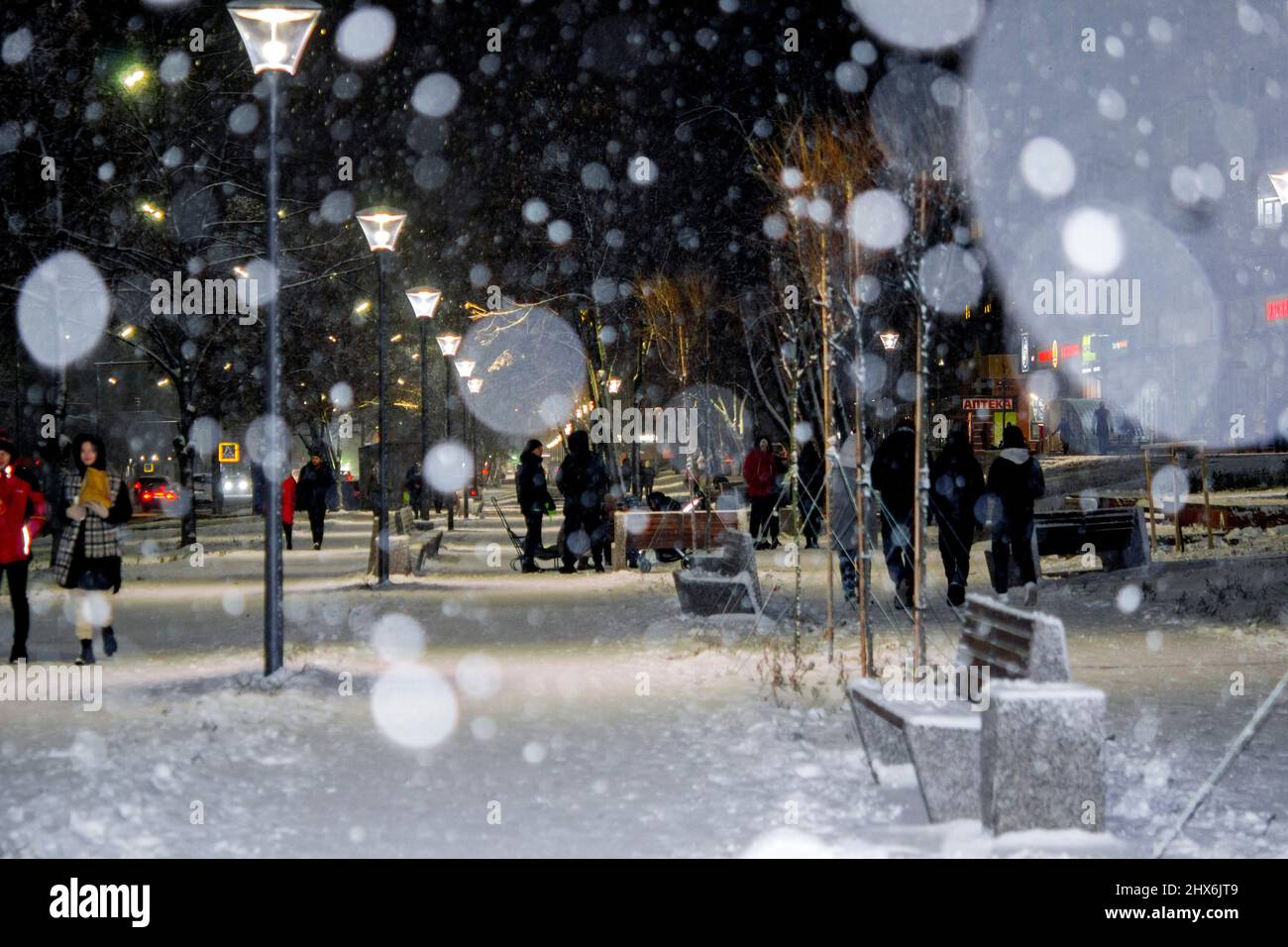 Blick auf die Stadt, Lichter, fallender Schnee, Nacht, Straße, Bokeh-Punkte Stockfoto
