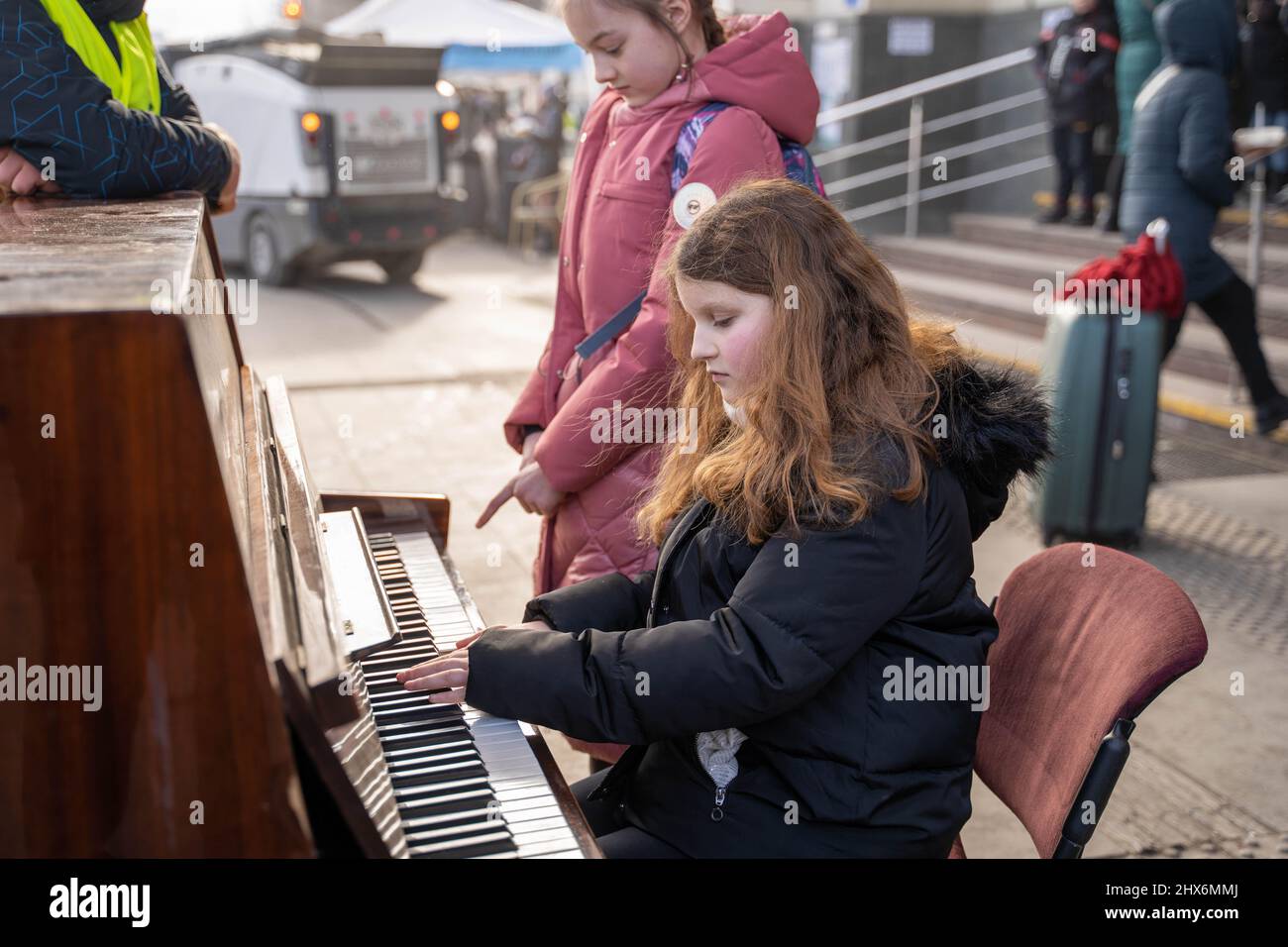 Lviv, Ukraine. 9. März 2022. Ein Mädchen spielt Klavier auf dem platz des Bahnhofs Lviv in Lviv, Ukraine, 9. März 2022. Quelle: Ren Ke/Xinhua/Alamy Live News Stockfoto