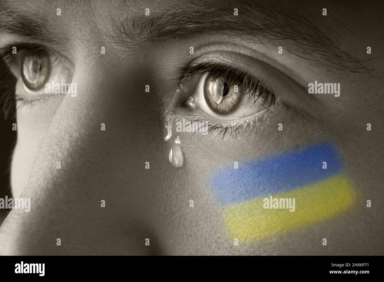 Mann mit ukrainischer Flagge, der weint. Russland und Ukraine Krieg. Rettet die Ukraine und beendet den Krieg Stockfoto