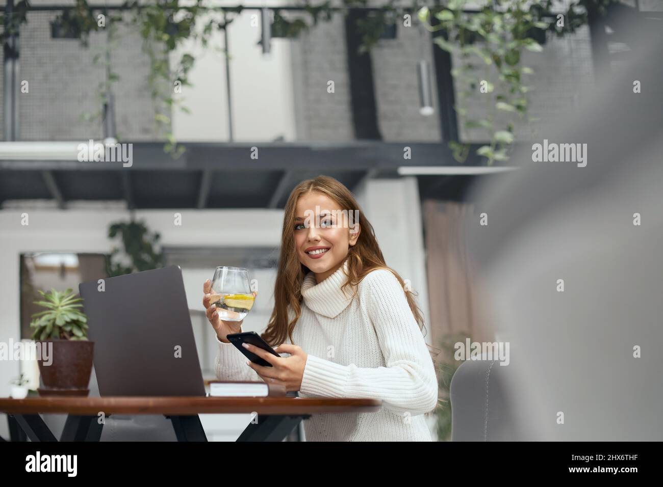 Porträt Einer Glücklichen Lächelnden Jungen Frau Mit Einem Glas Süßwasser Am Tisch Mit Notizbuch Im Café. Getränke. Stockfoto