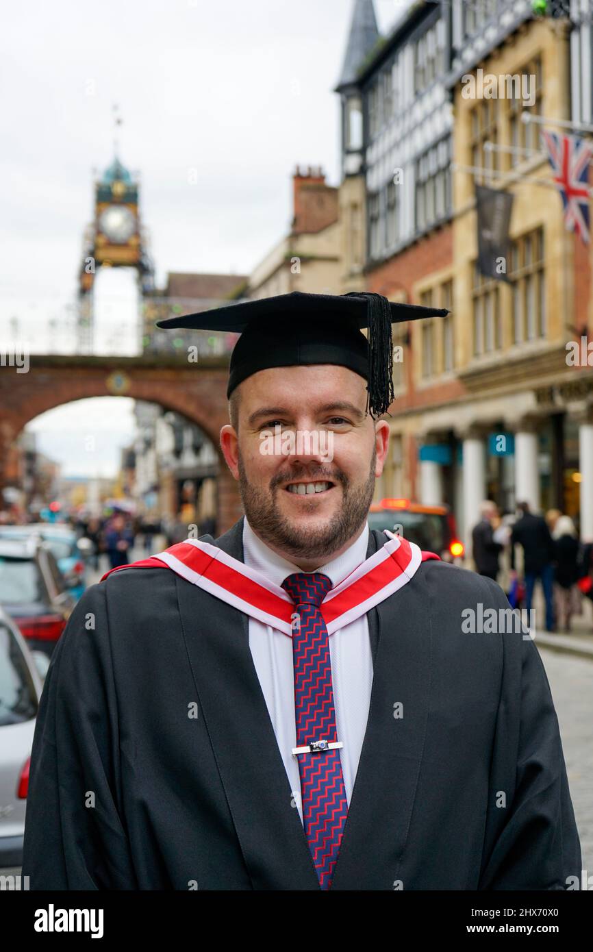 Reifer Student in Chester, der Abschlusskleid und Mortarboard trägt Stockfoto