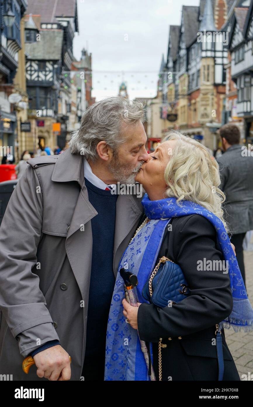 Ältere Paare, Männer und Frauen, Ehemann und Ehefrau, küssen sich im Stadtzentrum von Chester Stockfoto