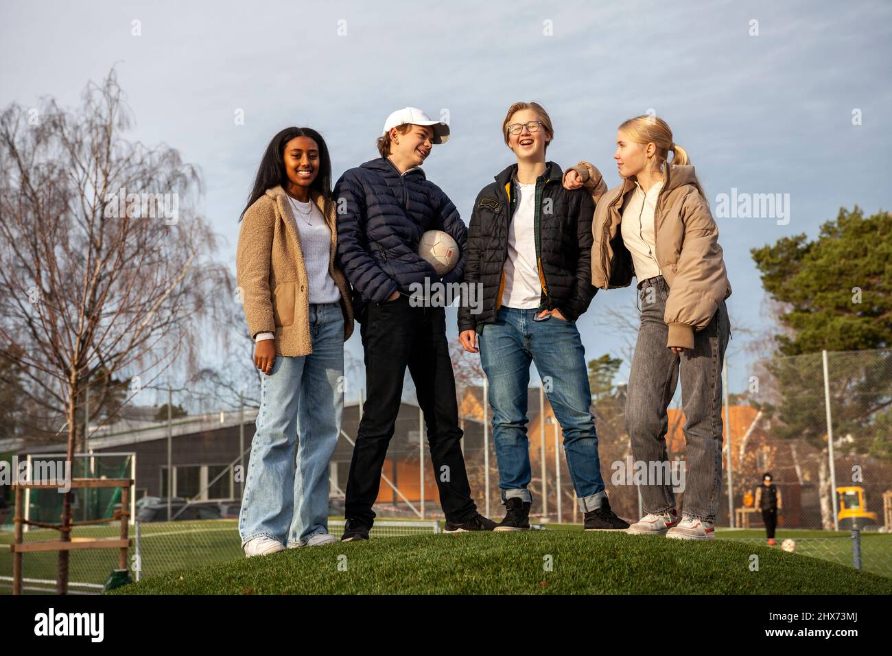 Porträt von Teenagerfreunden, die auf Gras stehen Stockfoto