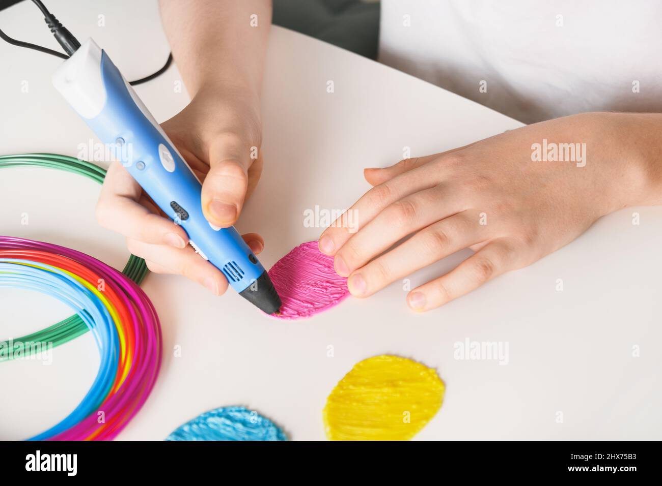 Kind machen Ostereier durch 3D Stift Kunststoff-Filamente auf weißem Hintergrund. Nahaufnahme. Stockfoto