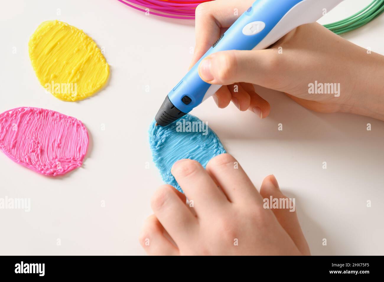 Kind macht Ostereier durch 3D Kugelschreiber Kunststoff-Filamente. Nahaufnahme. Stockfoto