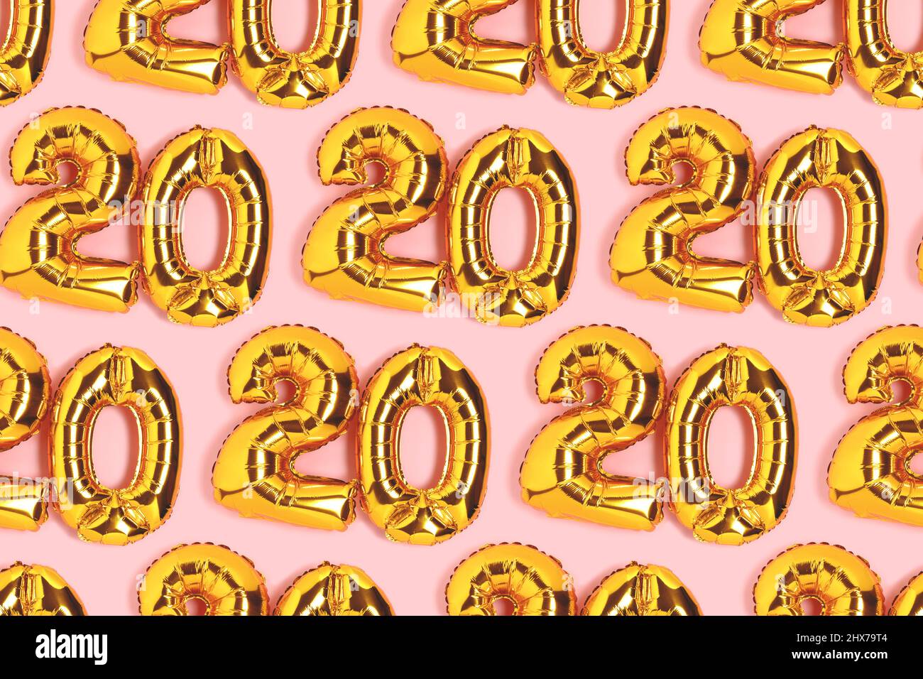 Zahlen 20 goldene Luftballons Muster. Konzept zur Feier des 20-jährigen Bestehens auf einem rosa Hintergrund. Stockfoto