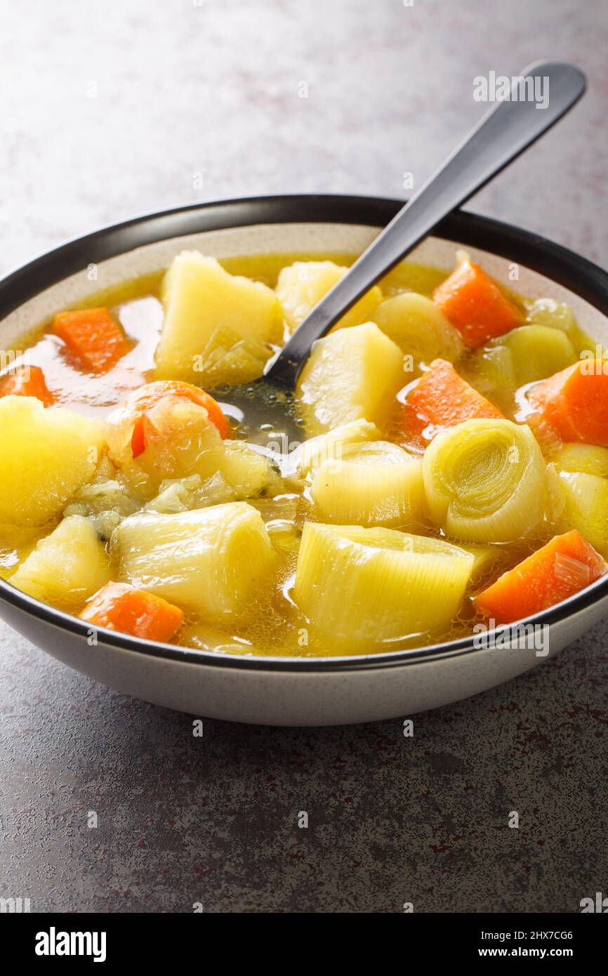 Porrusalda spanischer baskischer Lauch und Kartoffelsuppe in der Nähe auf dem Teller auf dem Tisch. Vertikal Stockfoto