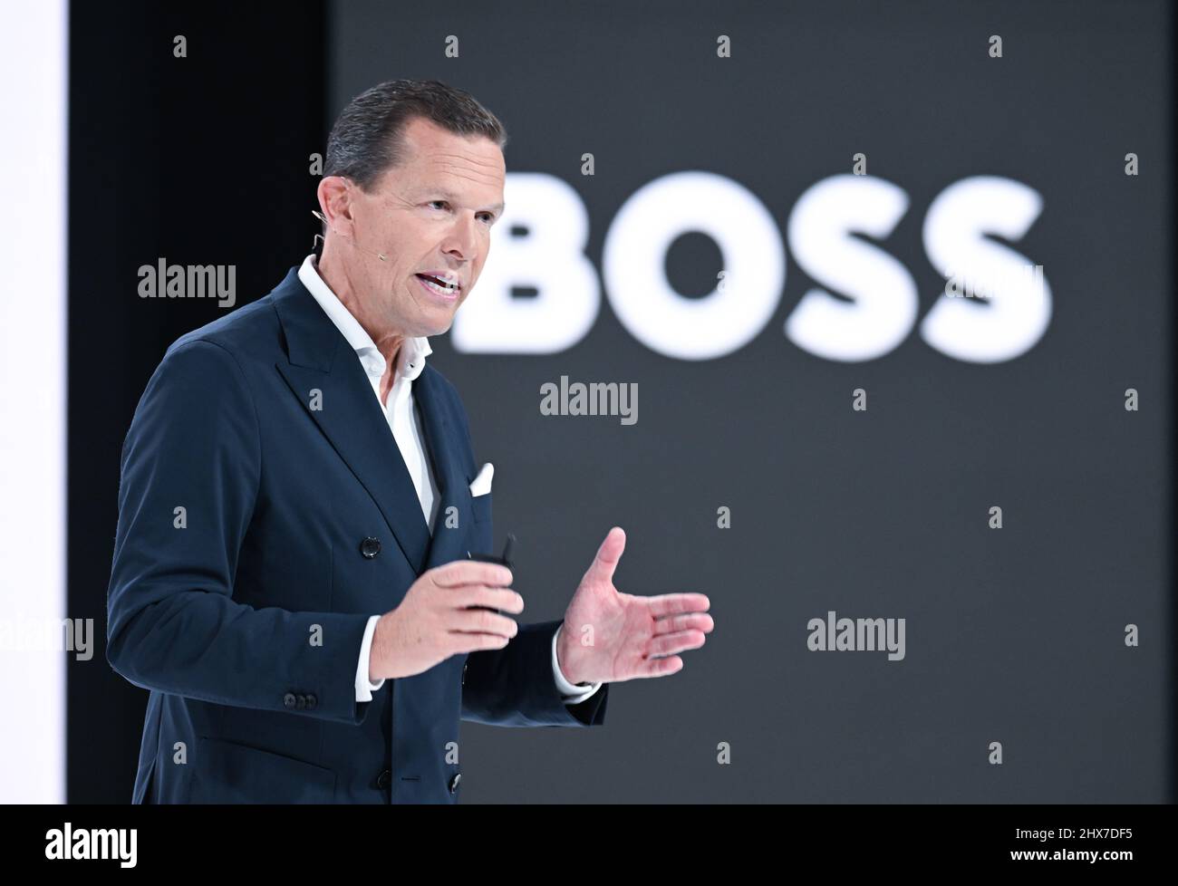 Filderstadt Sielmingen, Deutschland. 10. März 2022. Daniel Grieder, CEO des Modekonzerns Hugo Boss, steht während der Jahrespressekonferenz vor einer Videoleinwand mit einem Boss-Logo. Quelle: Bernd Weißbrod/dpa/Alamy Live News Stockfoto