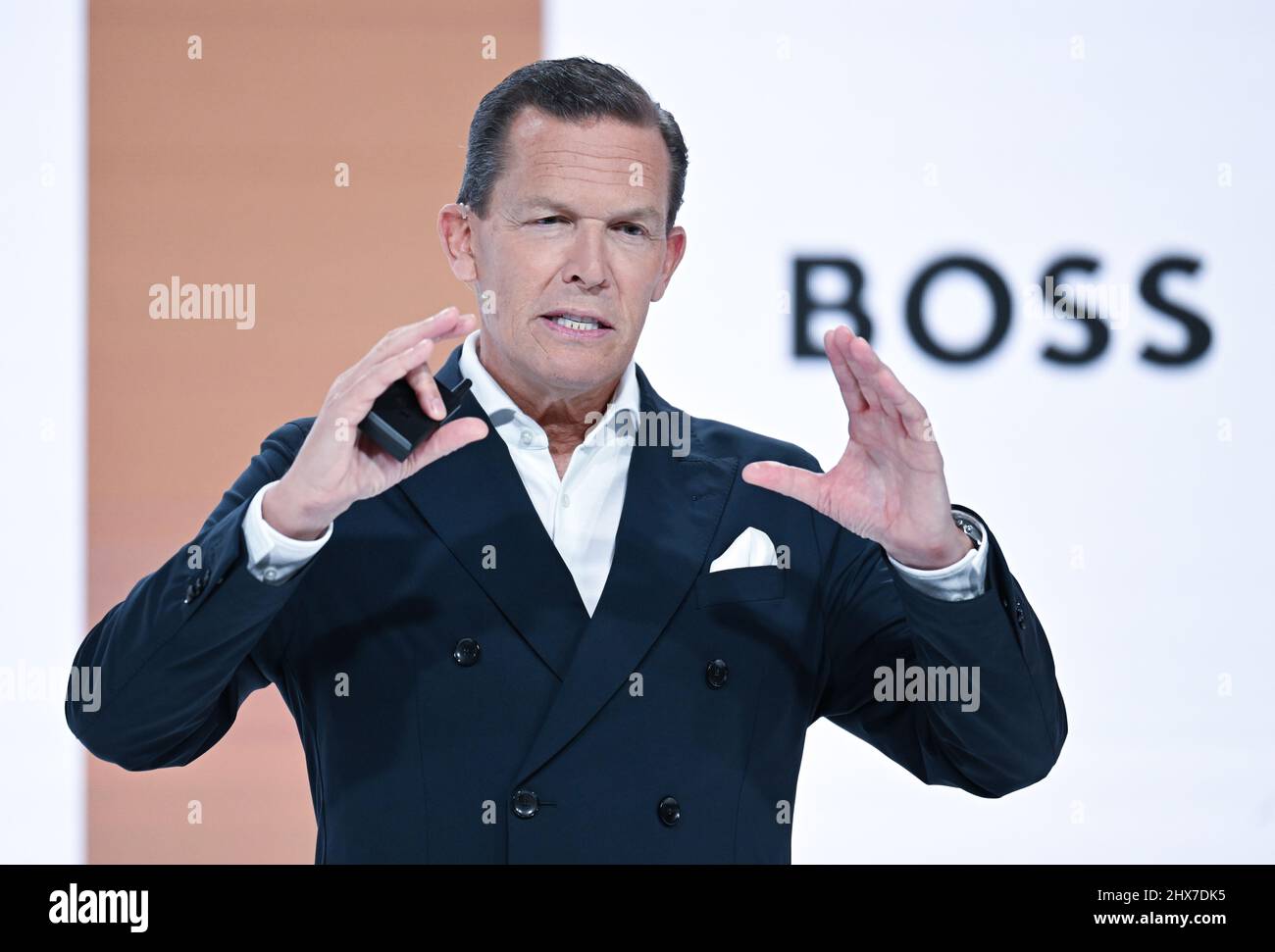 Filderstadt Sielmingen, Deutschland. 10. März 2022. Daniel Grieder, CEO des Modekonzerns Hugo Boss, steht während der Jahrespressekonferenz vor einer Videoleinwand mit einem Boss-Logo. Quelle: Bernd Weißbrod/dpa/Alamy Live News Stockfoto