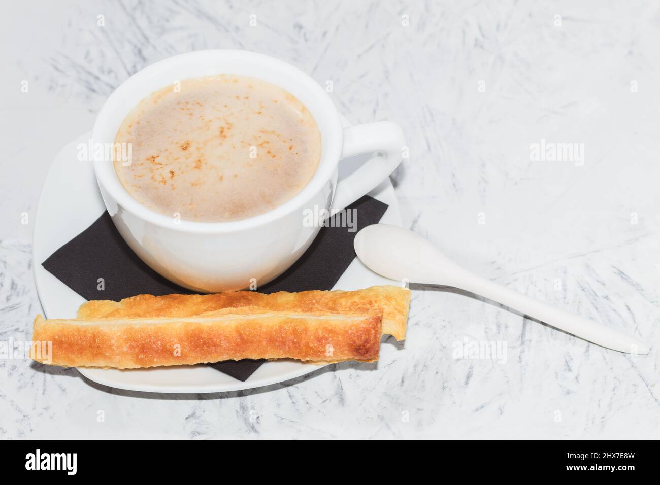 Frisches Gebäck und eine weiße Tasse Kaffee. Kaffee und Kekse. Hintergrund mit Kopierbereich Stockfoto