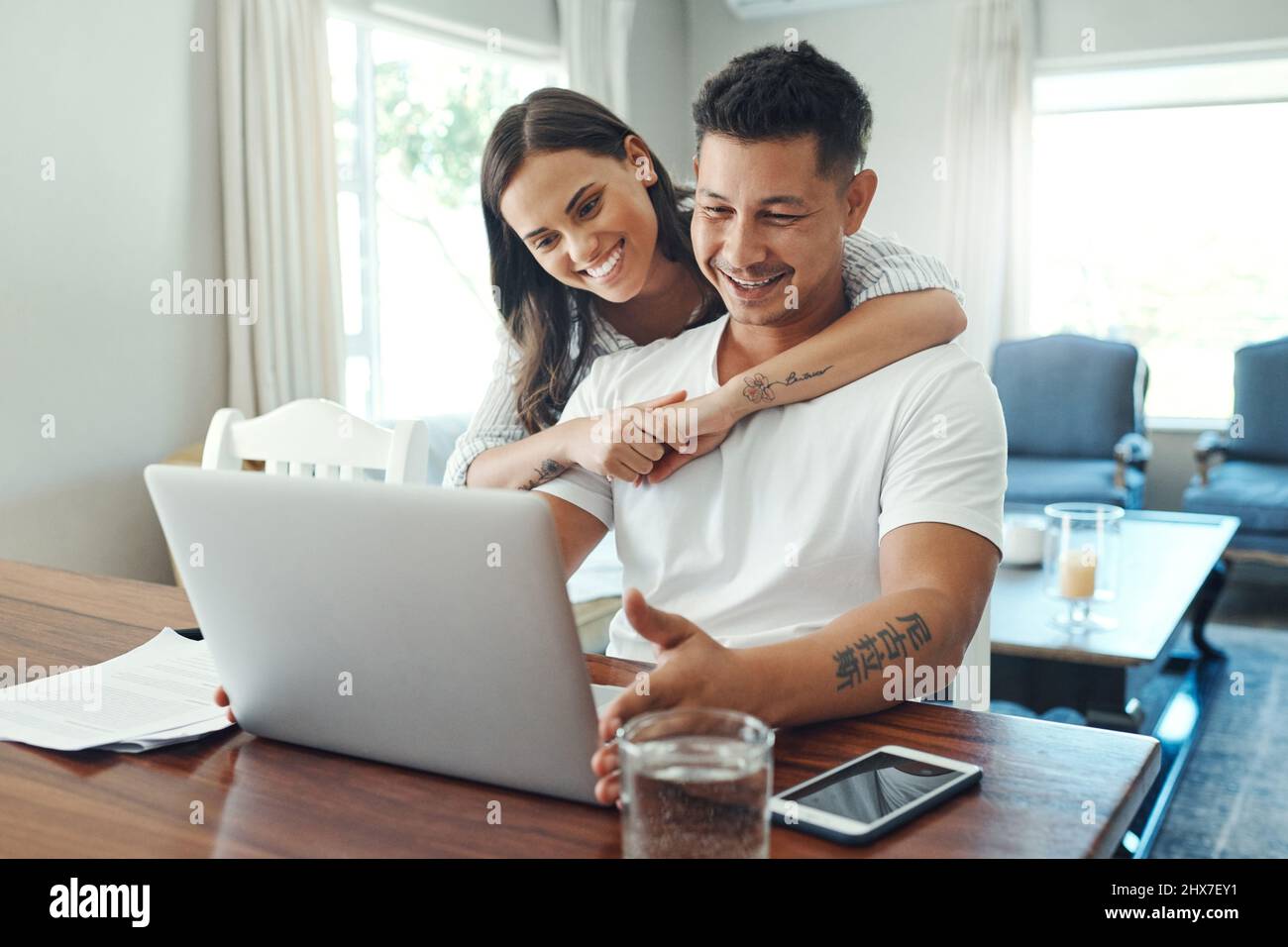 Unsere finanzielle Zukunft sieht gut aus. Eine kurze Aufnahme eines liebevollen jungen Paares, das einen Laptop für sein Haushaltsbudget im Wohnzimmer zu Hause verwendet. Stockfoto