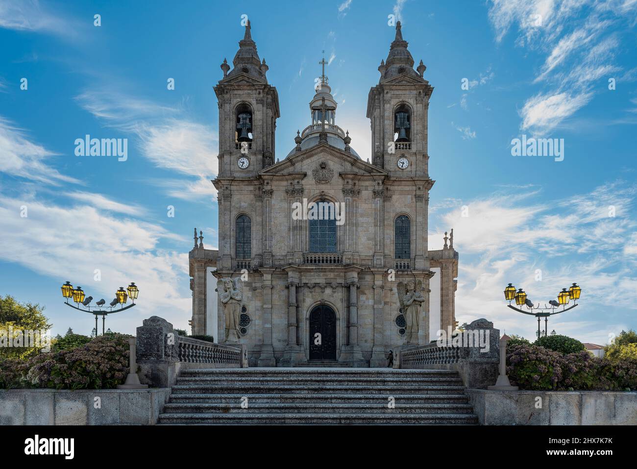 Fassade der Basilika von Sameiro in Portugal mit der Treppe im Vordergrund und den zwei riesigen Laternenpfosten an den Seiten. Stockfoto