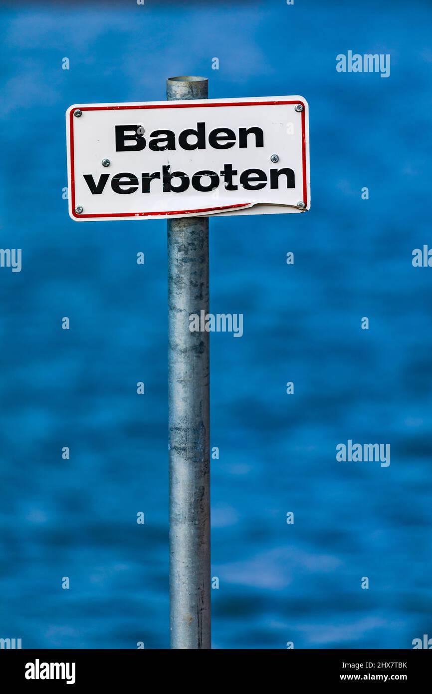 Deutsch kein Schwimmschild an einem Pfahl isoliert vor einem blauen See Stockfoto
