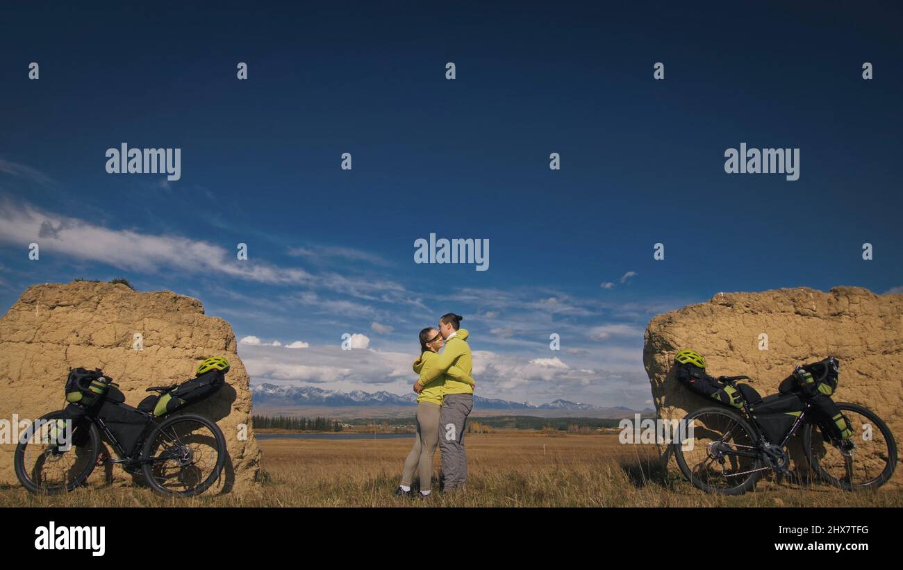 Der Mann und die Frau reisen mit Bikepacking auf gemischtem Terrain. Die beiden Personen reisen mit Fahrradtaschen. Sportbekleidung in grün bla Stockfoto