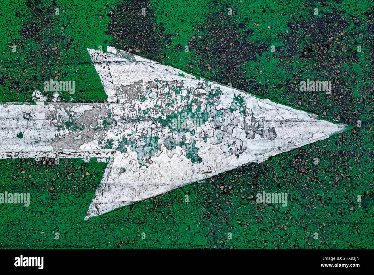 Großer gemalter grungy Pfeil auf verwittertem grünen Hintergrund Stockfoto
