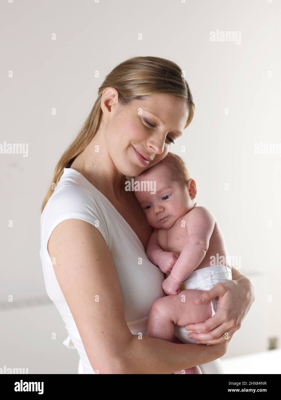 Frau kuschelt ihren kleinen Jungen, 8 Wochen Stockfoto