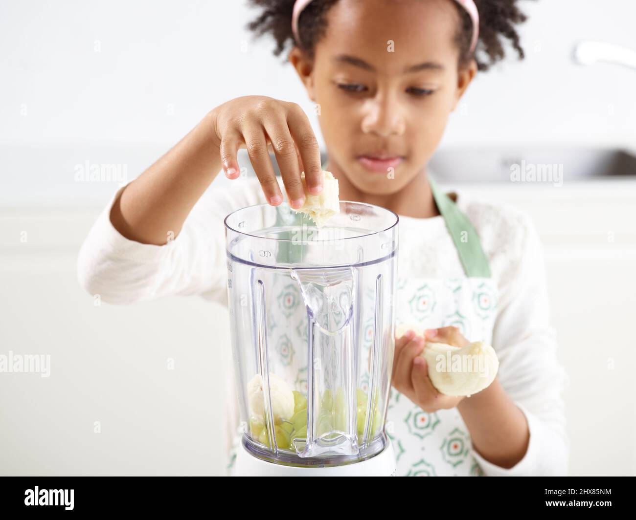 Grüner Smoothie - Weintrauben und Bananen in einen Mixer geben (Schritt 1 von 3) Stockfoto