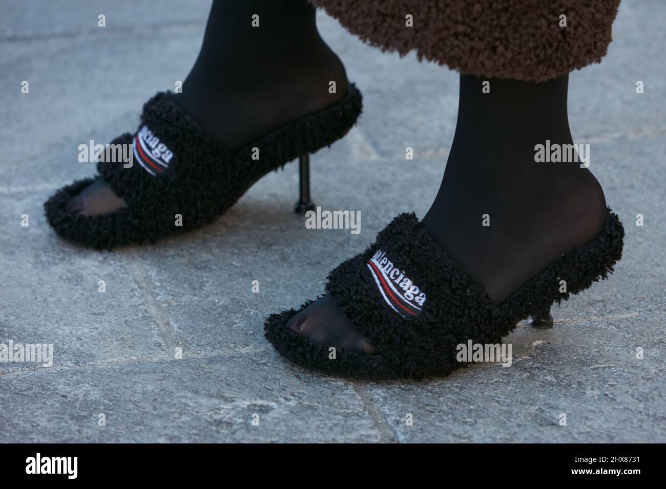 MAILAND, ITALIEN - 23. FEBRUAR 2022: Frau mit schwarzen Balenciaga-Schuhen mit Fell vor der Marco Rambaldi Fashion Show, Mailand Fashion Week Street Style Stockfoto