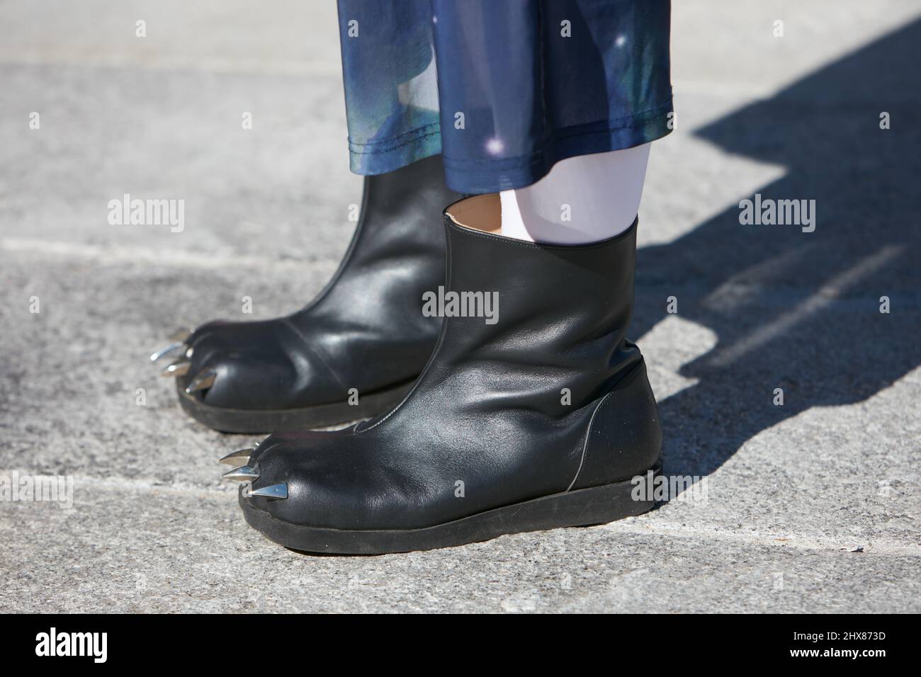 MAILAND, ITALIEN - 23. FEBRUAR 2022: Frau mit schwarzen Lederschuhen mit metallischen Krallen vor der Marco Rambaldi Modenschau, Mailand Fashion Week Street Sty Stockfoto