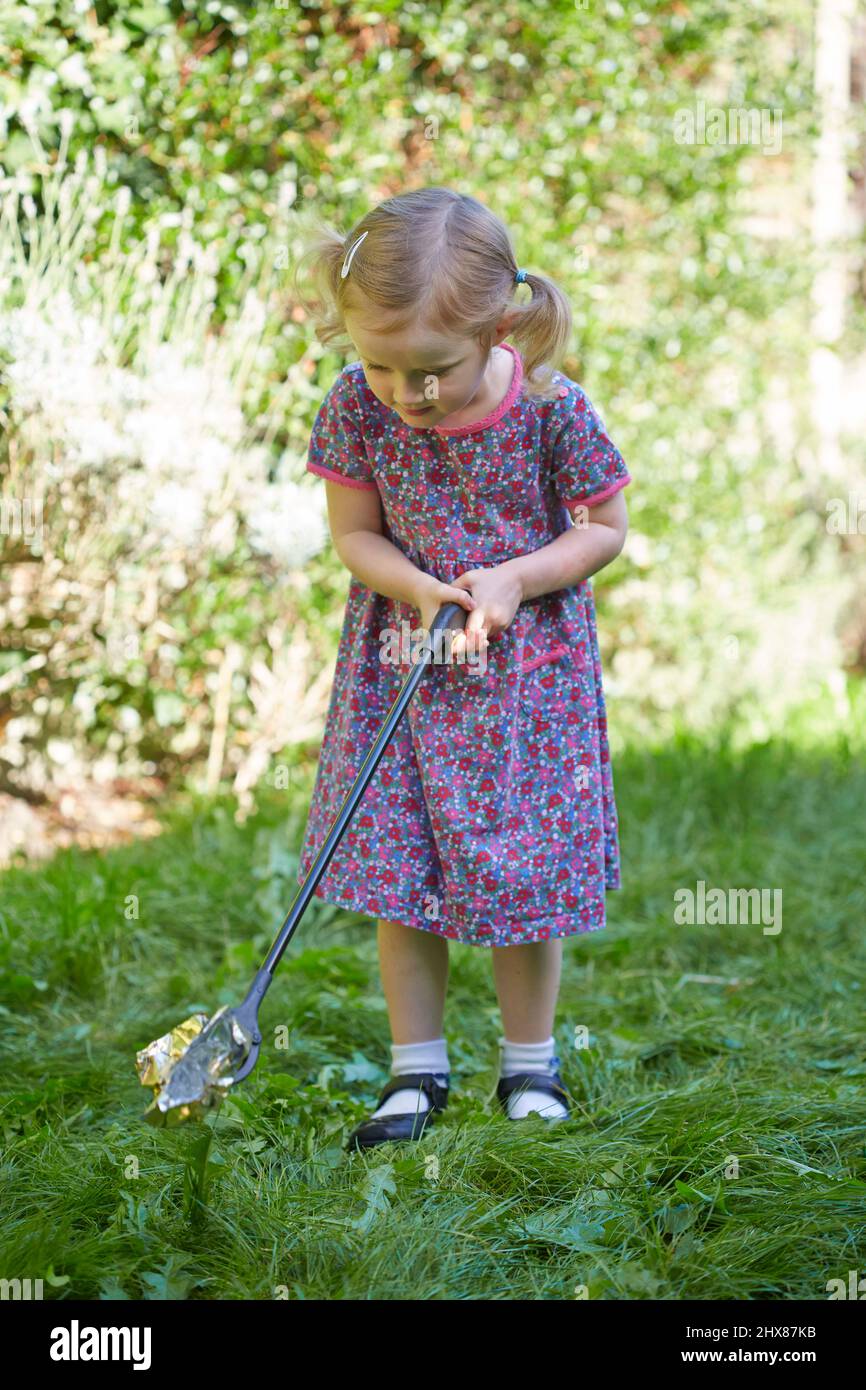 Kleines Mädchen mit Wurfpflücker draußen (Modell im Alter von 3 Jahren) Stockfoto