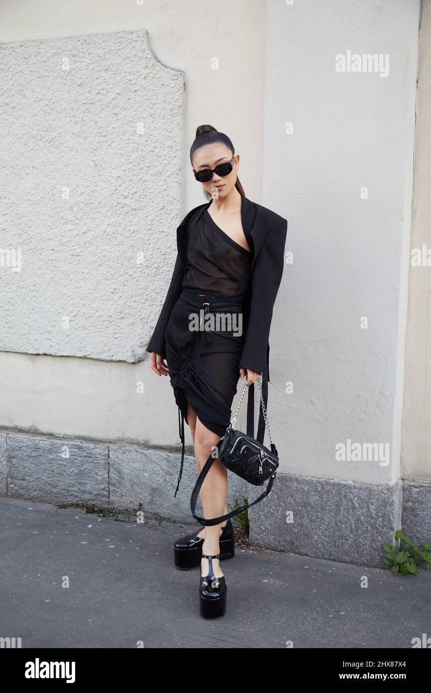 MAILAND, ITALIEN - 23. FEBRUAR 2022: Frau mit schwarzem Kleid und schwarzen Schuhen mit Keilabsatz vor der Alberta Ferretti Fashion Show, Mailand Fashion Week stre Stockfoto