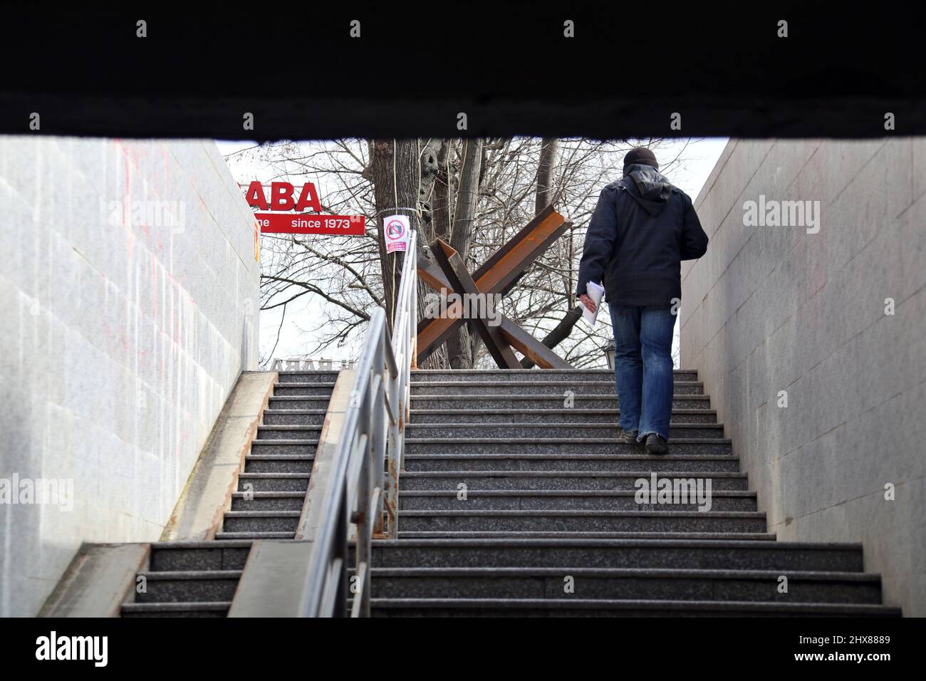 Non Exclusive: ODESA, UKRAINE - 9. MÄRZ 2022 - Ein Mann geht die Treppe eines unterirdischen Durchgangs als Panzerabwehrhindernis, bekannt als tschechischer Hedge Stockfoto