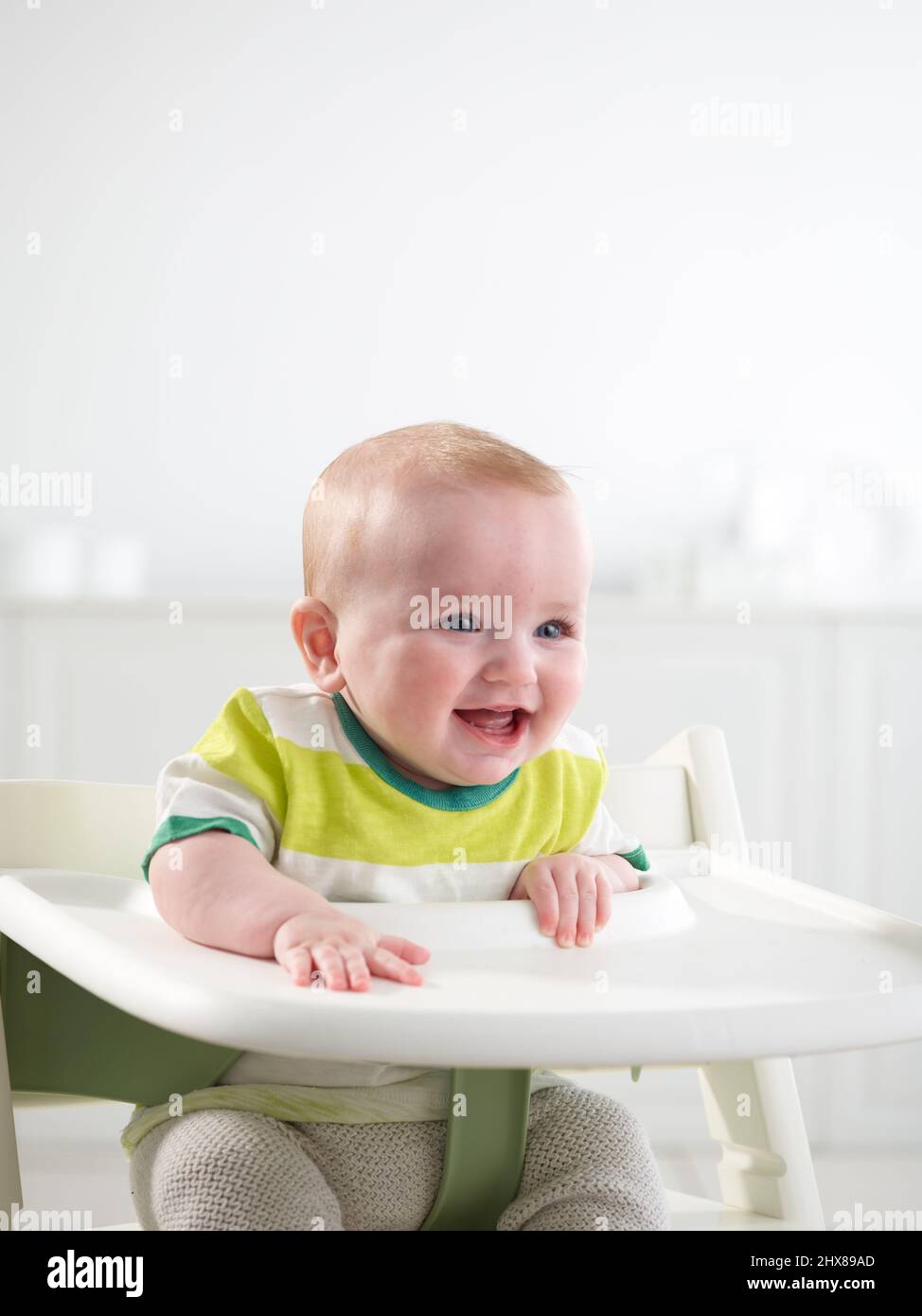 Baby im Alter von 6 Monaten im Hochstuhl Stockfoto