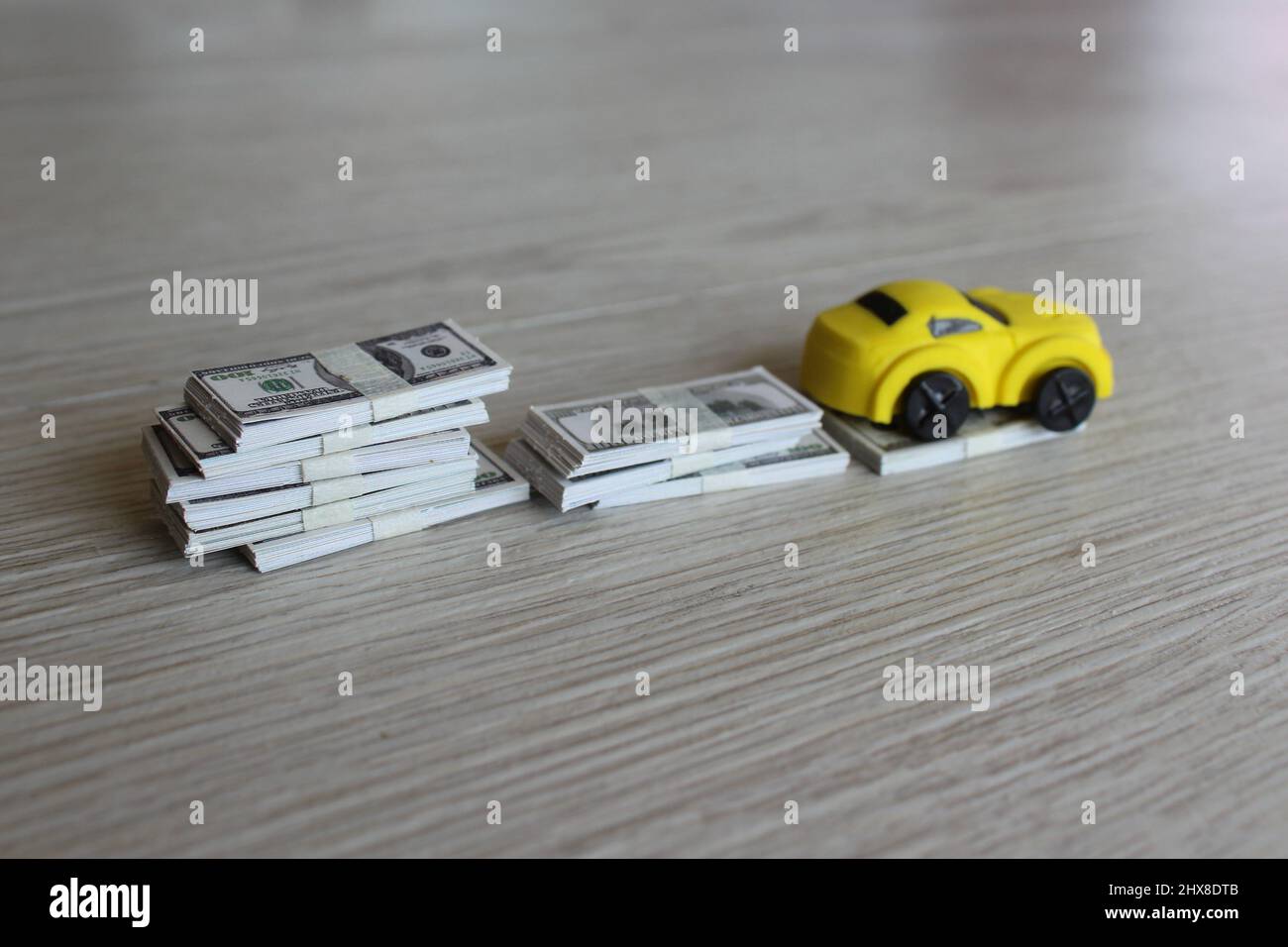 Selektives Fokusbild von Spielzeugauto und Geldstapel. Abschreibung Auto, Wertkonzept. Stockfoto