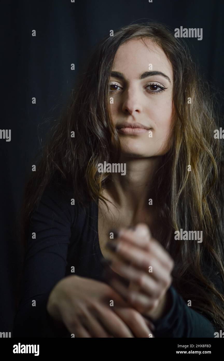 Porträt eines schönen italienischen Mädchen mit langen Haaren gestikulierend mit einem verführerischen Look Stockfoto